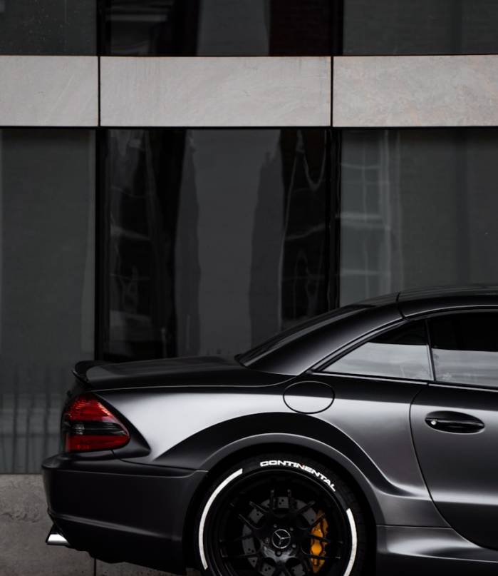 gray bmw m 3 coupe parked beside glass wall